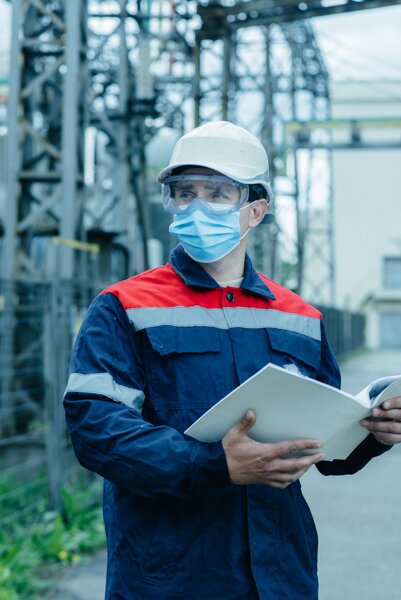 Guy wearing a white helmet and holding a white book